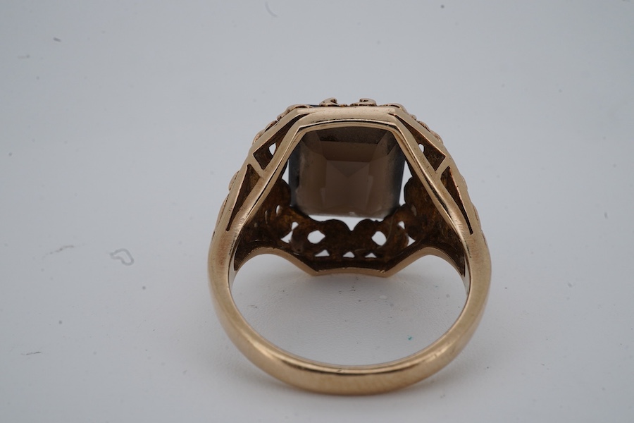 A smoky quartz dress ring, set with a step-cut smoky quartz, to a scrolled mount, size O, stamped PPLd 9CT, numbered, gross weight 6 grams